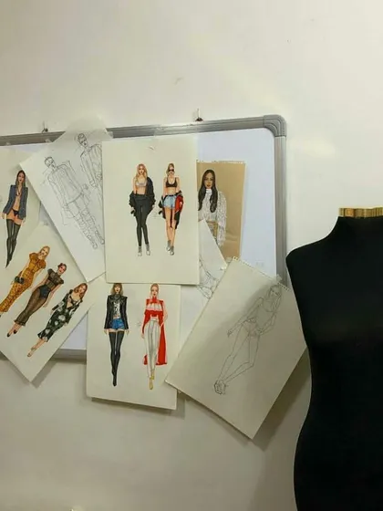 A view of our design studio, where student illustrations are pinned up for review next to a dressmaker's mannequin. This shows the creative environment where ideas are developed and critiqued before moving to the pattern-making stage.