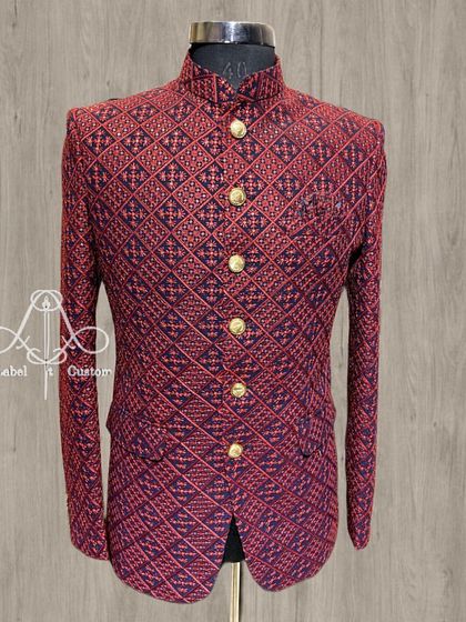 This red and navy bandhgala showcases a dense, geometric pattern for a bold and sophisticated look. It's a testament to how traditional patterns can be used to create a powerful, contemporary piece of formal wear.