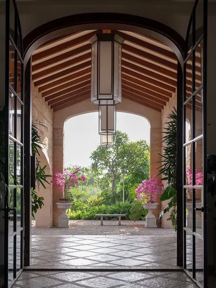 A grand entrance should feel like a welcoming embrace from nature. For this Alibaug villa, I framed the garden view with an archway, creating a living picture that draws you in. The flowering bougainvillea adds a splash of color, promising a serene escape within.
