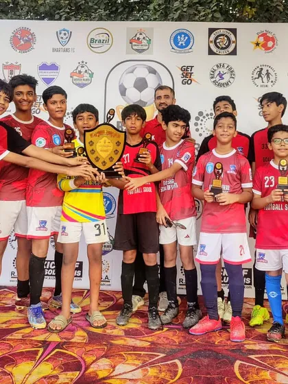 Lifting the trophy high. Our U-13 boys celebrating their championship win.