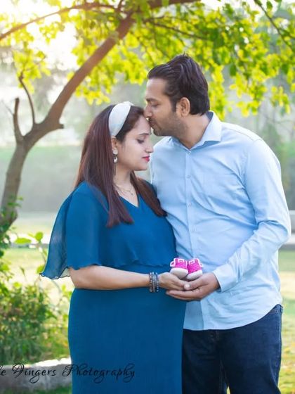 A gentle and emotional maternity portrait of a husband kissing his wife's forehead. The soft, natural lighting and serene park background make this a truly special moment.