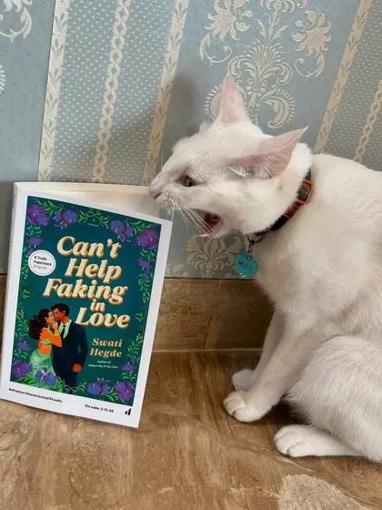 Just two pretty girls with a pretty book. My cat might look like she's screaming at my book, *Can't Help Faking in Love*, but I promise she's a fan.