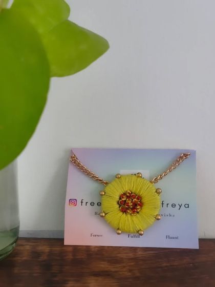 A bright and cheerful yellow flower necklace. This piece is made with thread embroidery and has a beaded center, perfect for a summery, bohemian vibe.