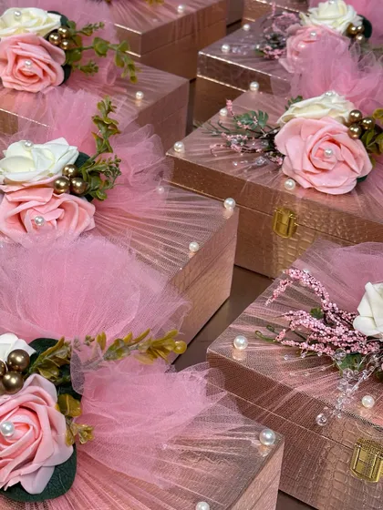 These rose-gold wedding favor boxes are the definition of elegance. Each box is adorned with pink and white roses, pearls, and delicate tulle.