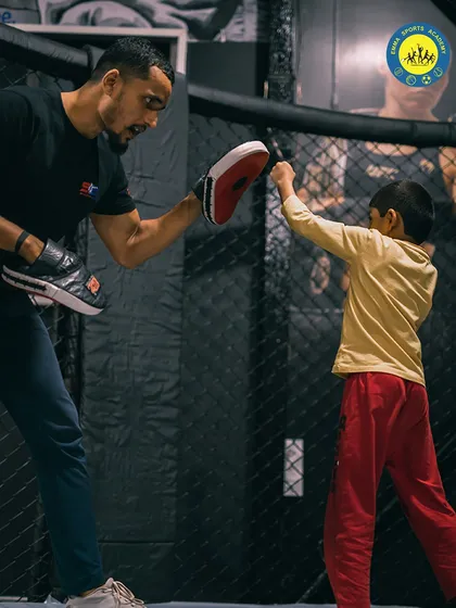 A young student practices his punches with a coach. I believe in starting early to build discipline, confidence, and strong self-defense skills.