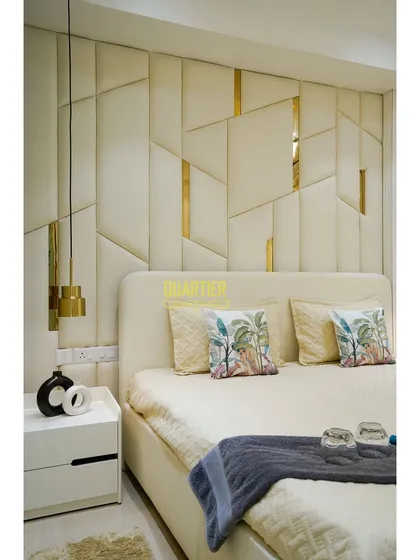 A different angle of the master bedroom at Tata La Vida, showing the geometric upholstered headboard. The play of light and shadow on the asymmetrical panels creates a dynamic and visually engaging feature.
