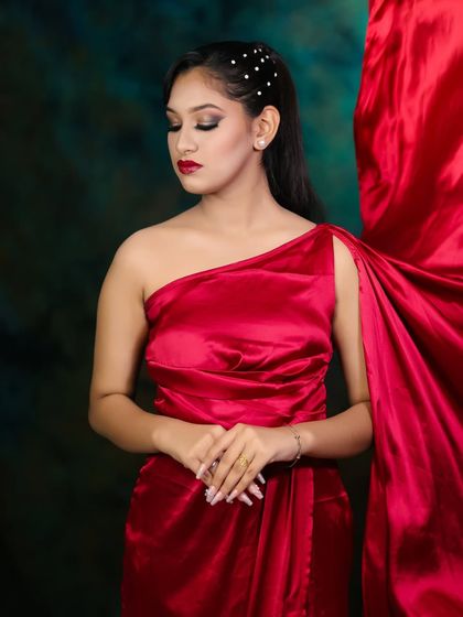 A full-body shot showing how the red satin dress complements the makeup for a complete, cohesive look.