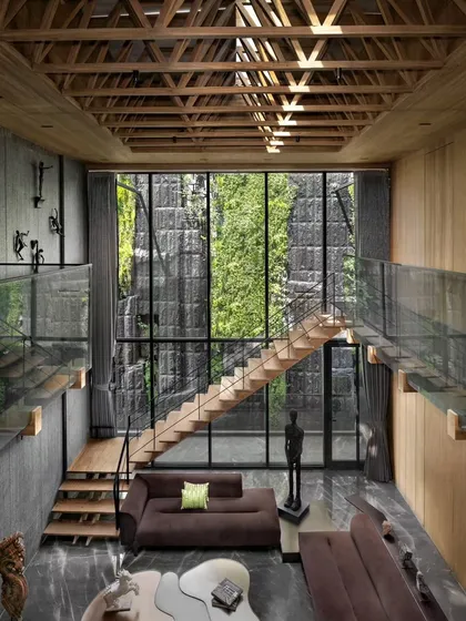 I believe architecture must connect us to nature. In this luxury residence, we dissolved the walls with floor-to-ceiling glass, creating a seamless flow between the living area and the lush, multi-story green wall. The design brings the five elements, especially पृथ्वी (Earth) and वायु (Air), right into the home.