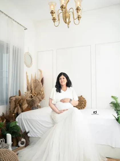 A beautiful solo portrait in a white mermaid gown. This shot, taken in my bright and airy boho-themed studio set, perfectly captures the pregnancy glow.