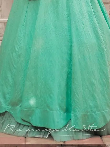 The hem of the turquoise lehenga, showing the layered construction with a net under-skirt that provides volume and a graceful fall.