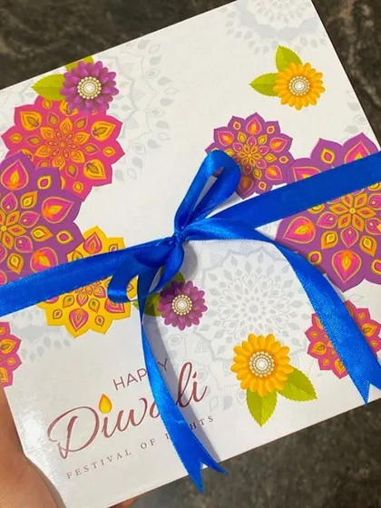 A finished Diwali gift box, tied with a festive blue ribbon. Ready to bring a smile to someone's face.