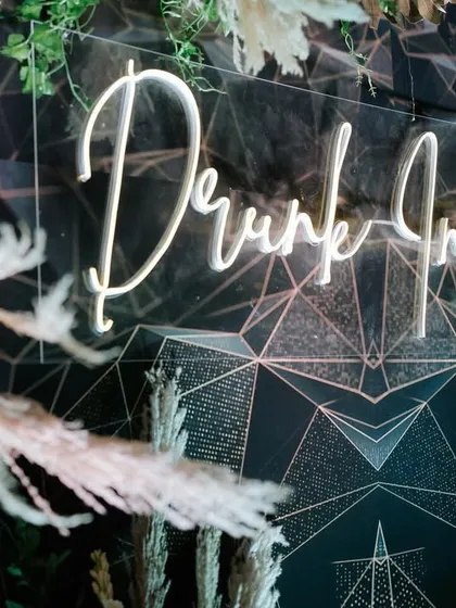 A chic 'Drunk In Love' neon sign adds a fun and modern touch to the bar area. I love incorporating these custom details that reflect the couple's personality and enhance the party vibe.