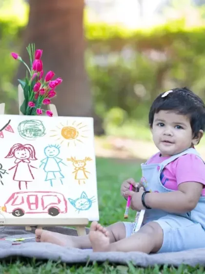 A baby artist proudly showing off her colorful family drawing.