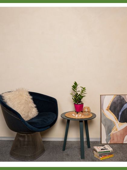 A cozy corner setup featuring a ZZ plant in a bright pink pot. This plant is extremely hardy and tolerates low light, making it an ideal choice for adding a touch of green to any office nook.