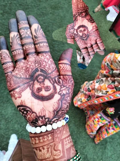 A close-up of a groom's portrait on the palm, showing the fine details in the face and turban.