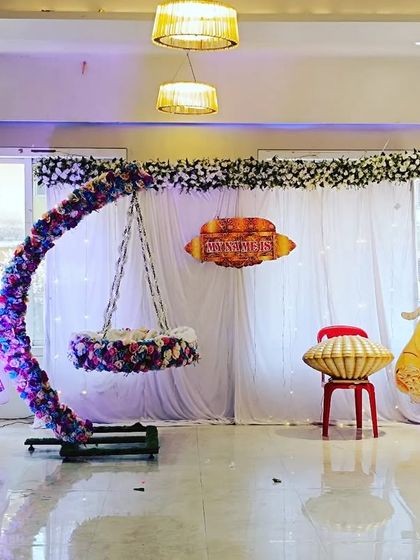 A princess-themed naming ceremony setup with a floral moon-shaped cradle and cutouts of various Disney princesses, creating a magical atmosphere.