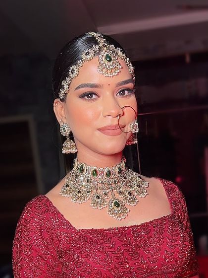 A classic portrait of the bride, looking directly at the camera. Her confidence shines through, complemented by the perfectly sculpted makeup and regal jewelry.