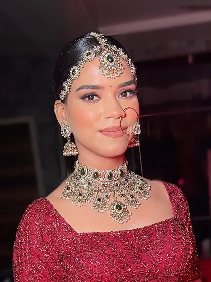 A classic portrait of the bride, looking directly at the camera. Her confidence shines through, complemented by the perfectly sculpted makeup and regal jewelry.
