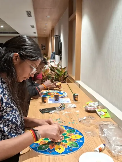 A student carefully applies mirrors to her Lippan art piece. This traditional craft requires patience and precision, and the results are always rewarding.