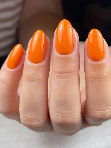 A bold and bright orange manicure. This glossy, cheerful color is sure to make you smile every time you look at your hands.