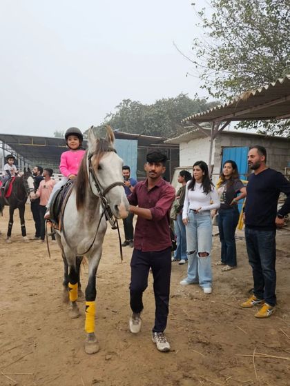 A family watches on as their child takes a lesson. Horse riding is an activity the whole family can enjoy together.