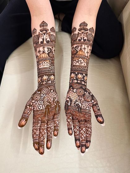 A very dense and detailed design covering the hands and arms, featuring elephants, peacocks, and lotus flowers. This is for the bride who wants a truly traditional and full look.