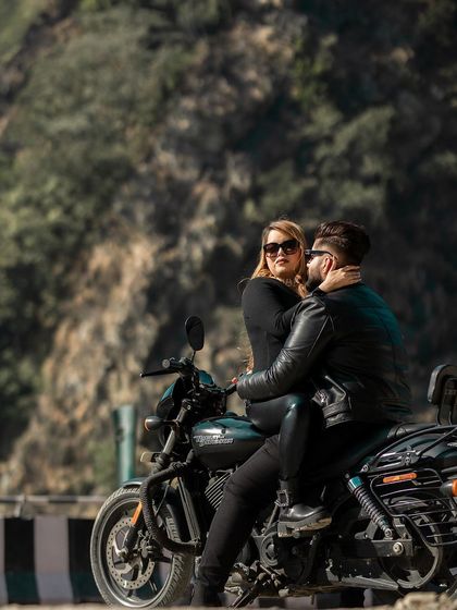 An intimate and edgy shot of the couple on a Harley Davidson, set against the rugged mountain terrain. This kind of adventure pre-wedding photography is perfect for couples who share a love for the open road.