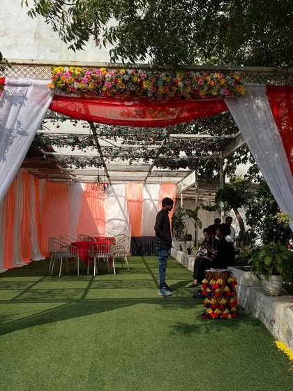 An outdoor tent setup with red and white drapes, perfect for creating a shaded seating area for guests during a daytime event.