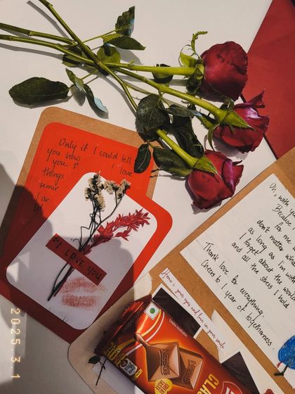 A close-up of the "I Love You" card from the anniversary hamper, featuring a lipstick print and dried flowers.