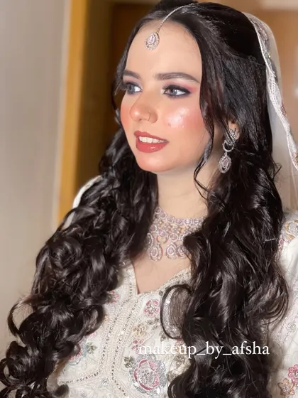 A close-up portrait. Her smile is radiant, and the makeup enhances her natural beauty perfectly.