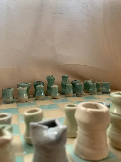 The pastel-glazed pieces of the 'Cocoa Clash' chess set, ready for a charming checkmate.
