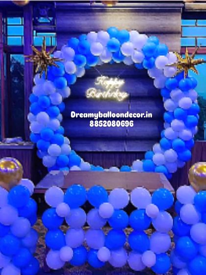 A simple yet striking blue and white birthday backdrop. The full balloon ring with a neon sign is perfect for a clean, modern look.