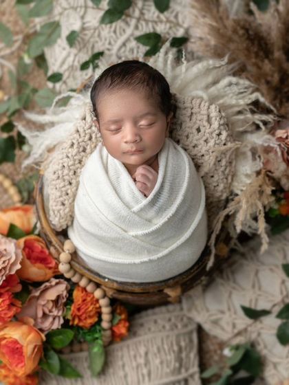 A newborn nestled in a bowl, surrounded by earthy tones and natural elements. This boho-inspired setup is both rustic and beautiful.