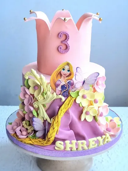 Another view of the Rapunzel cake, highlighting the sculpted crown and the flow of her braided hair.