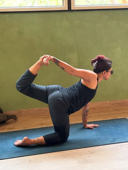 A student practices a one-legged tiger pose, a beautiful posture that challenges balance and opens the hip flexors and shoulders.