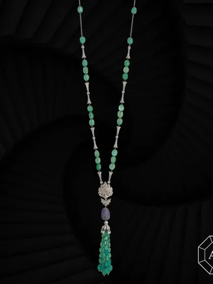 Our exquisite lariat necklace features emerald tumbles, sapphires, rose-cut and round diamond enhancers, and a striking diamond pendant at its center.