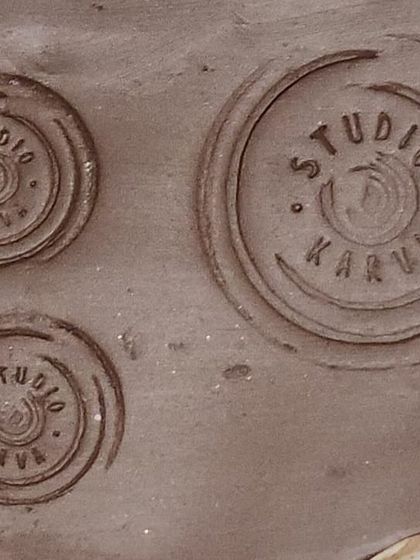 A close-up of the impressions made by our studio stamps in wet clay. This small detail connects every piece back to its origin and the many hands involved in its creation.