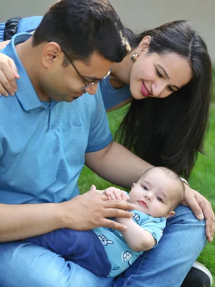 A tender moment between parents and their baby during an outdoor session. The natural setting and soft light add a warm and gentle feel to this family photo.