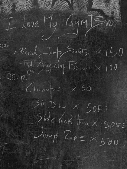 A look at the chalkboard during an OG program workout. The rep counts are high and the movements are challenging, designed to build serious endurance.