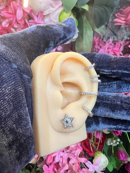 An ear styling model showing a simple yet elegant combination of a star stud and multiple hoops.
