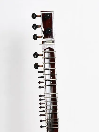 A close-up of the neck and tuning pegs of an Ustad Vilayat Khan style sitar. The craftsmanship ensures that the instrument is not only beautiful but also stays in tune.