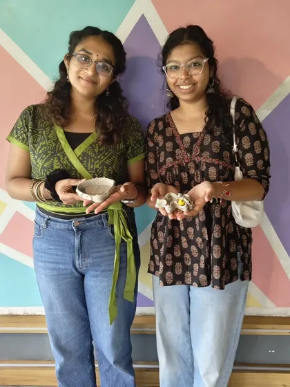 Two friends showing off the small clay bowls they made. Even simple, beginner-friendly projects result in a piece of handmade art to take home and cherish.