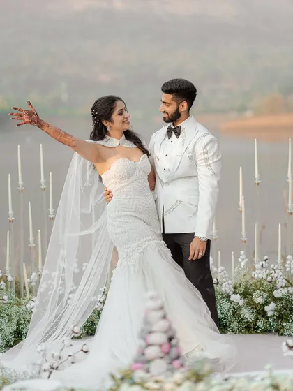 A modern fairytale unfolds by the lakeside. The bride, in her stunning white gown, shares a joyful moment with her groom. This image showcases our ability to capture the elegance and romance of contemporary white weddings.
