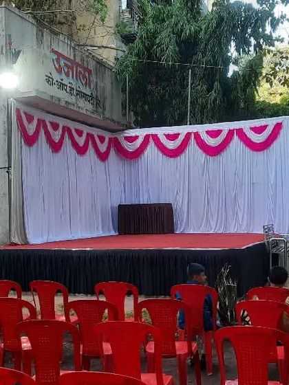 A simple stage and seating setup for a small community event. The butterfly wing props add a fun touch for a children's program.