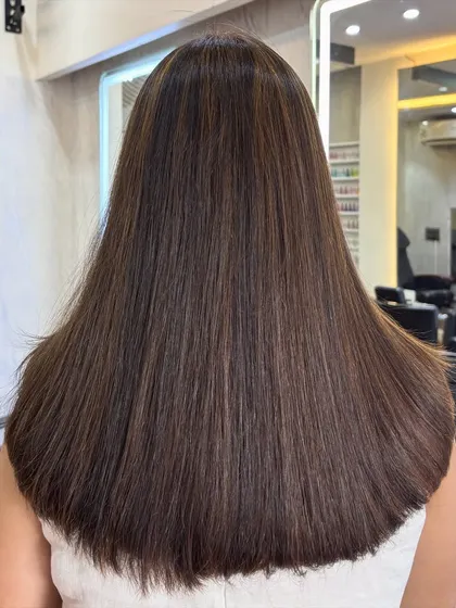 The back view of this espresso brown style shows how the highlights are woven through the hair to create a natural, sun kissed effect. The straight styling makes it look incredibly sleek.