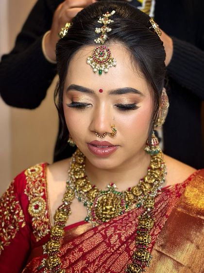 A final touch being added to the hair, with the makeup looking complete and flawless.