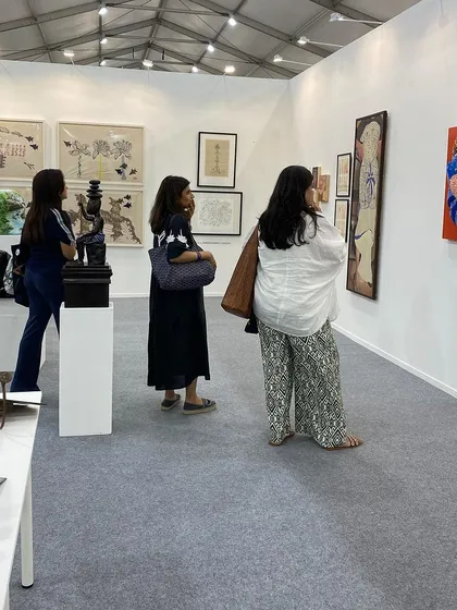 More visitors exploring the diverse collection of art at our booth.