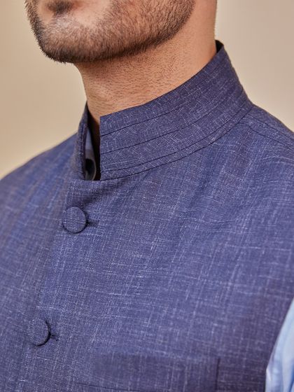 A modern twist on a classic style. This close-up shows the texture of a linen-blend waistcoat in a rich blue, perfect for daytime ceremonies or smart-casual events.