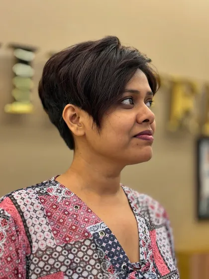 A side profile of a modern pixie haircut. This angle shows the texture and layering that give this short style its shape and movement.