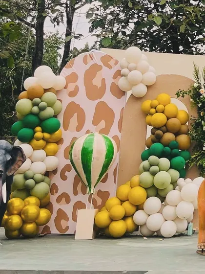 A detailed shot of the balloon art and animal props from Avyaan's safari party, featuring a leopard-print patterned backdrop panel and an elephant figure.